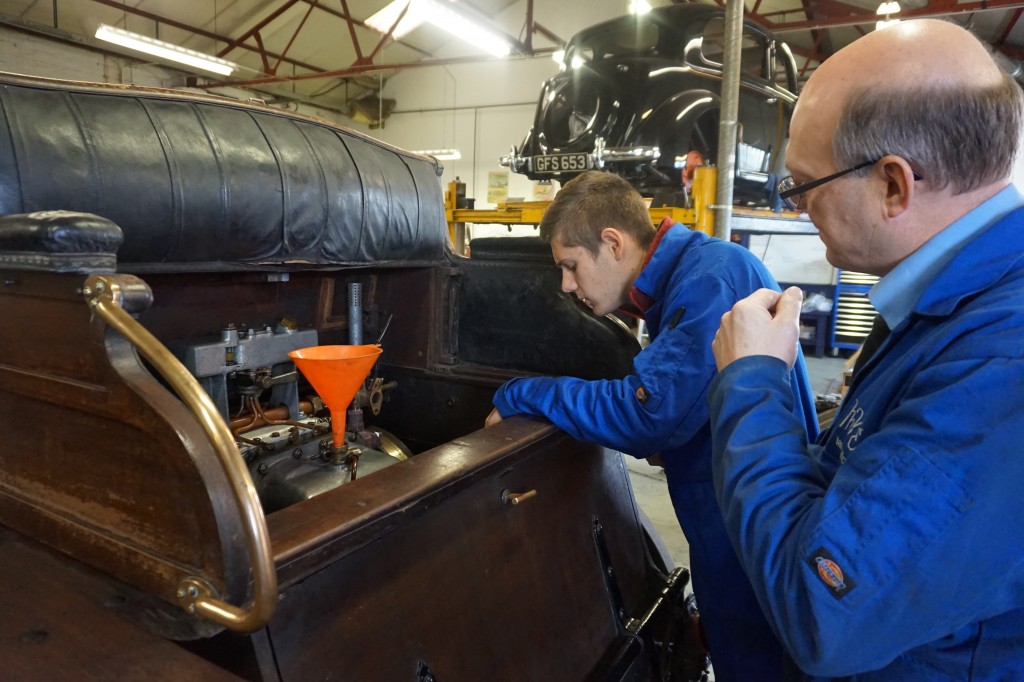 Ian explains the intricacies of  servicing this car to our French work experience student 